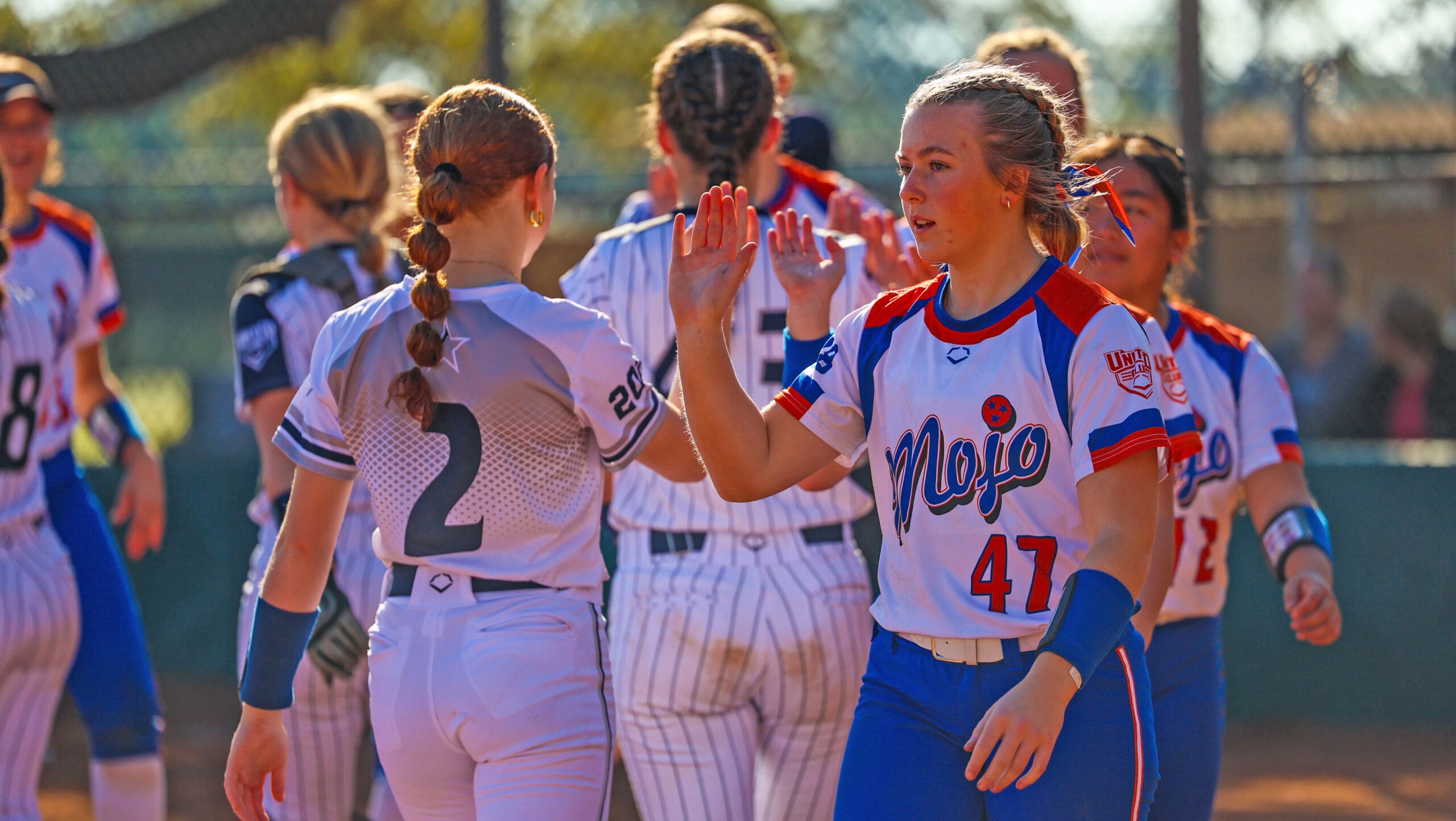 Teams exchange high fives after a game at the Florida Fall Showcase.