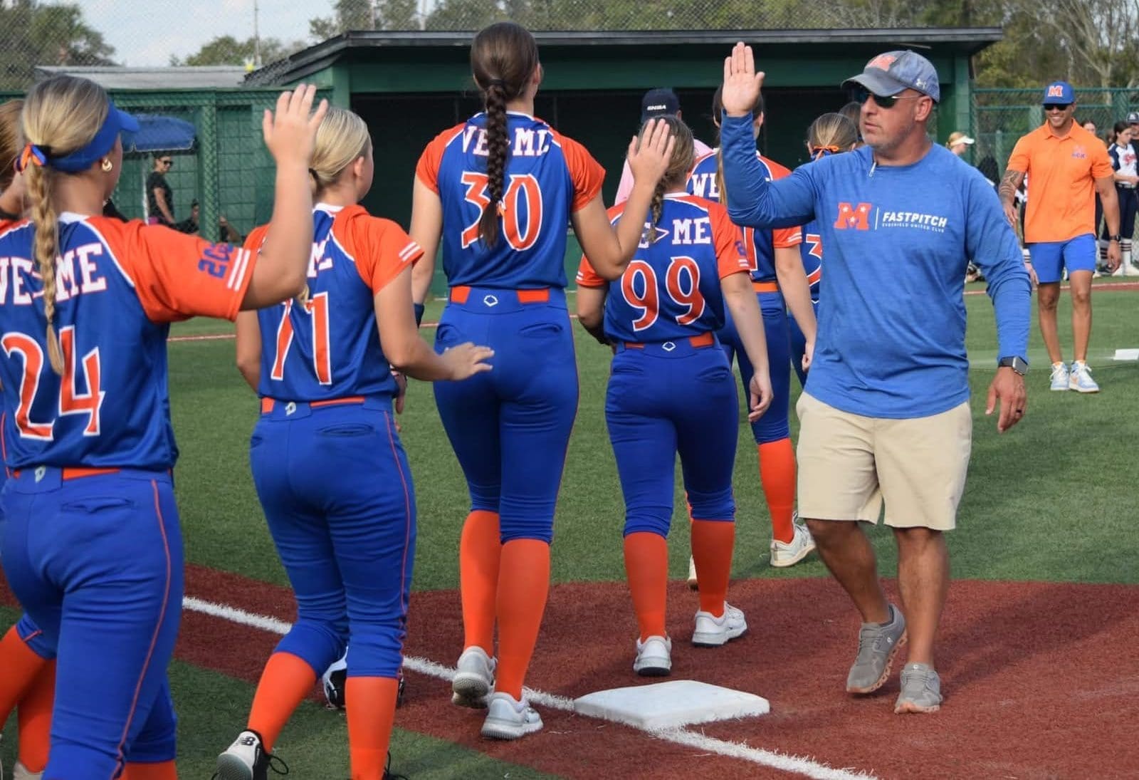 Coach Pardue gives high-fives following a strong performance by Mojo Pardue. His athletes say his encouragement builds belief and accountability.
