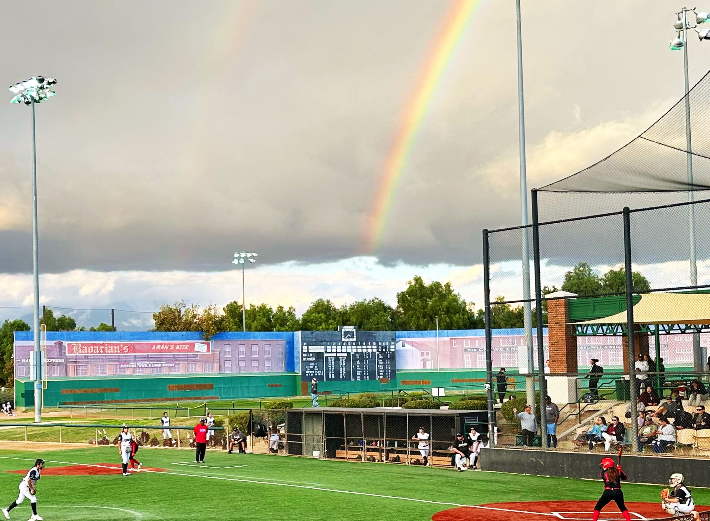 A rainbow stretches over the ballpark during competition at the Zoom Into June fastpitch showcase.