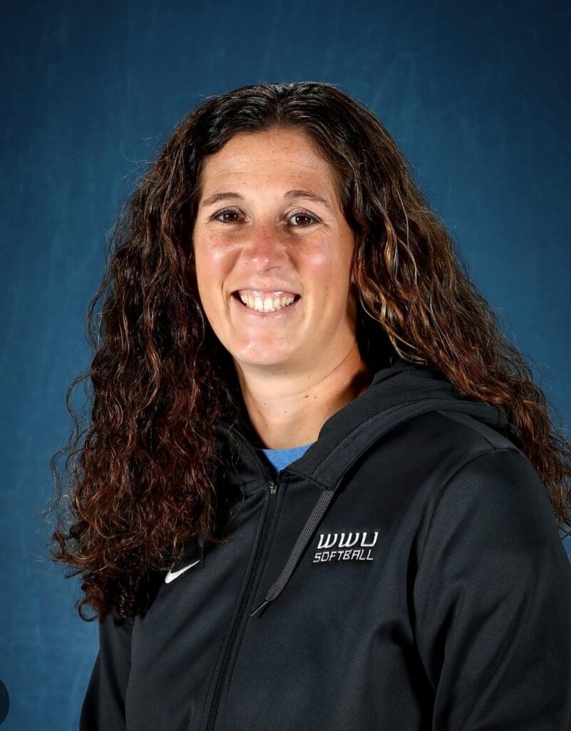 Amy Suiter poses for a portrait in a WWU softball jacket.